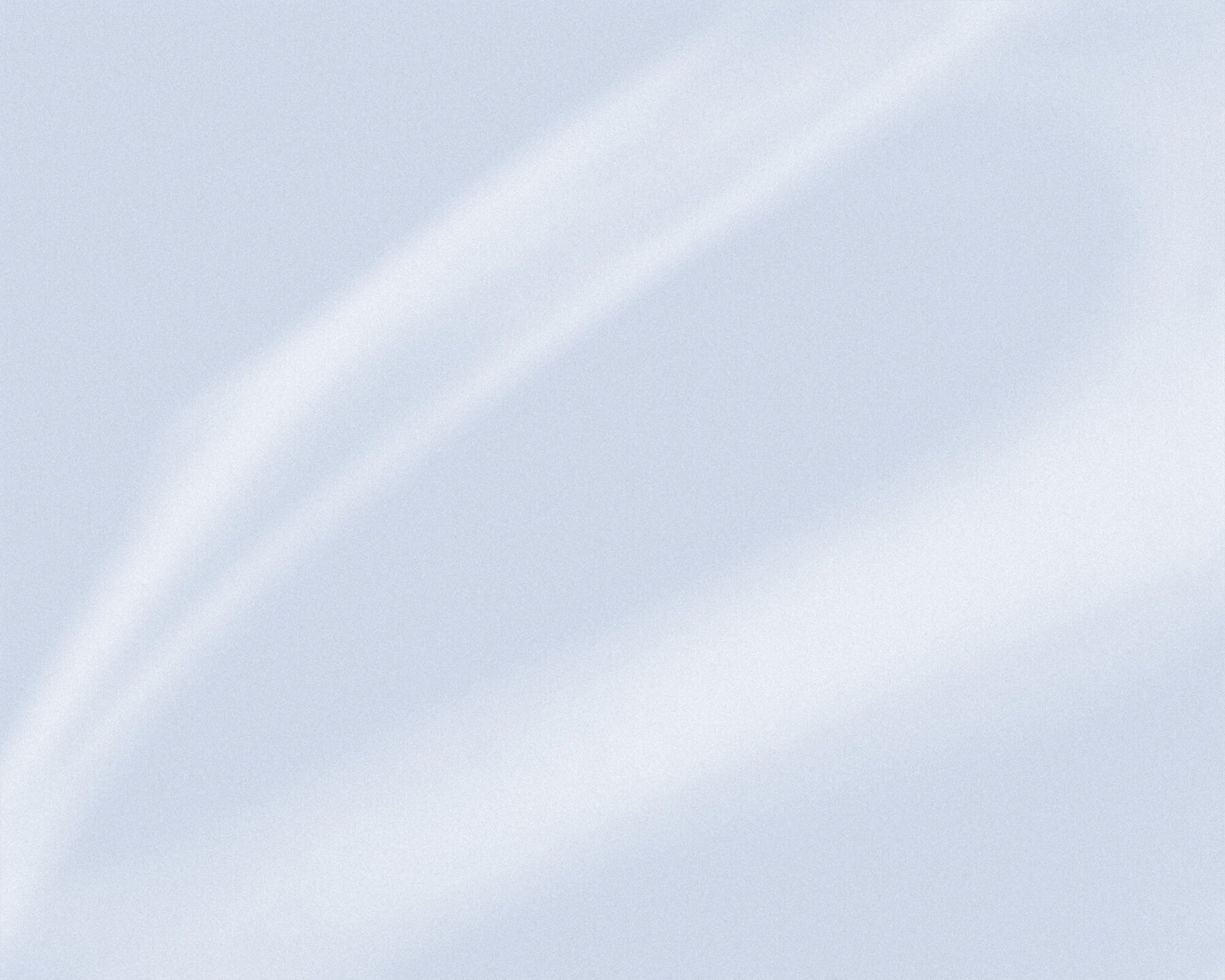 A pale blue-grey surface with a soft band of white light falling diagonally from the upper left to the lower right