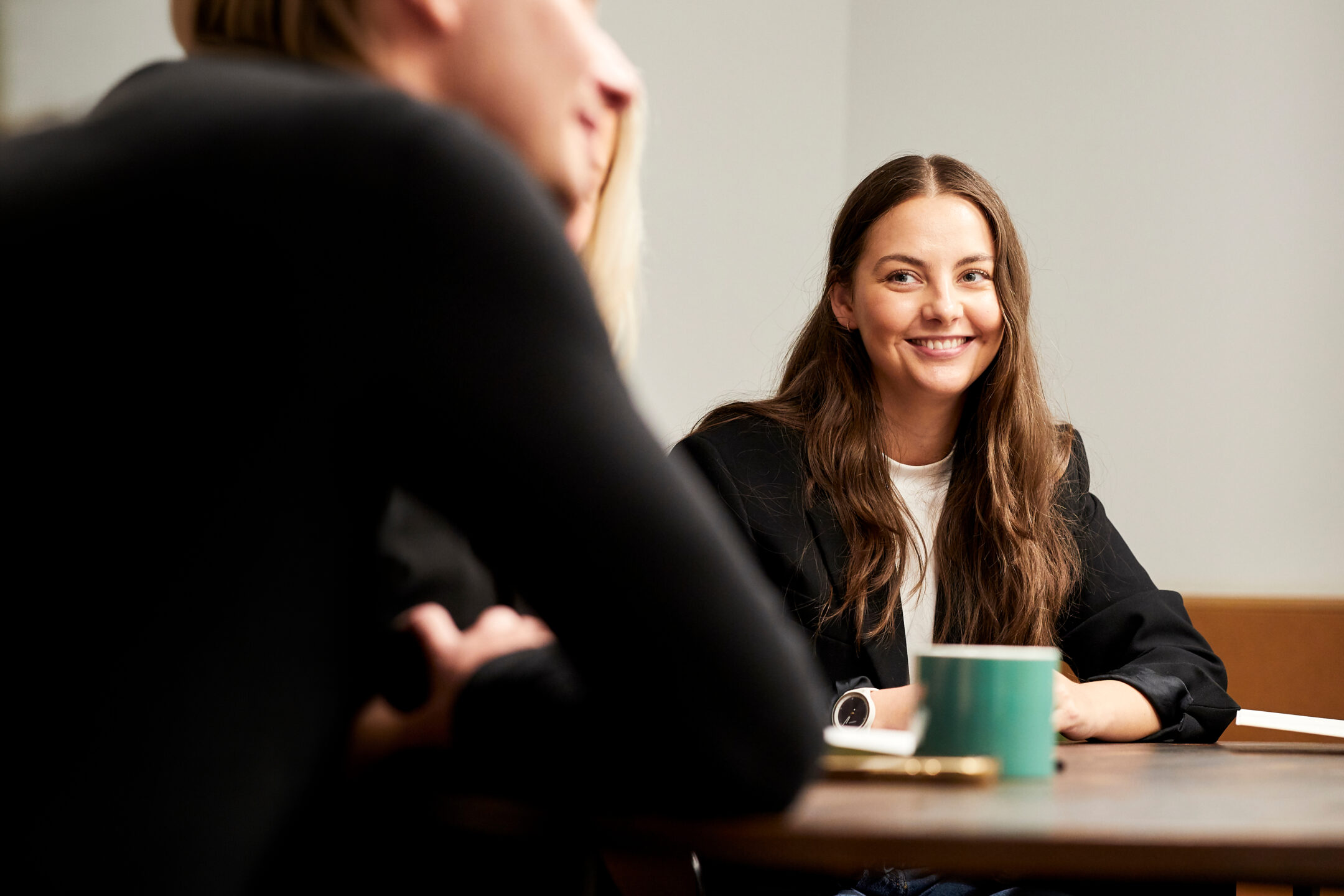 Two colleagues in conversation across a meeting table