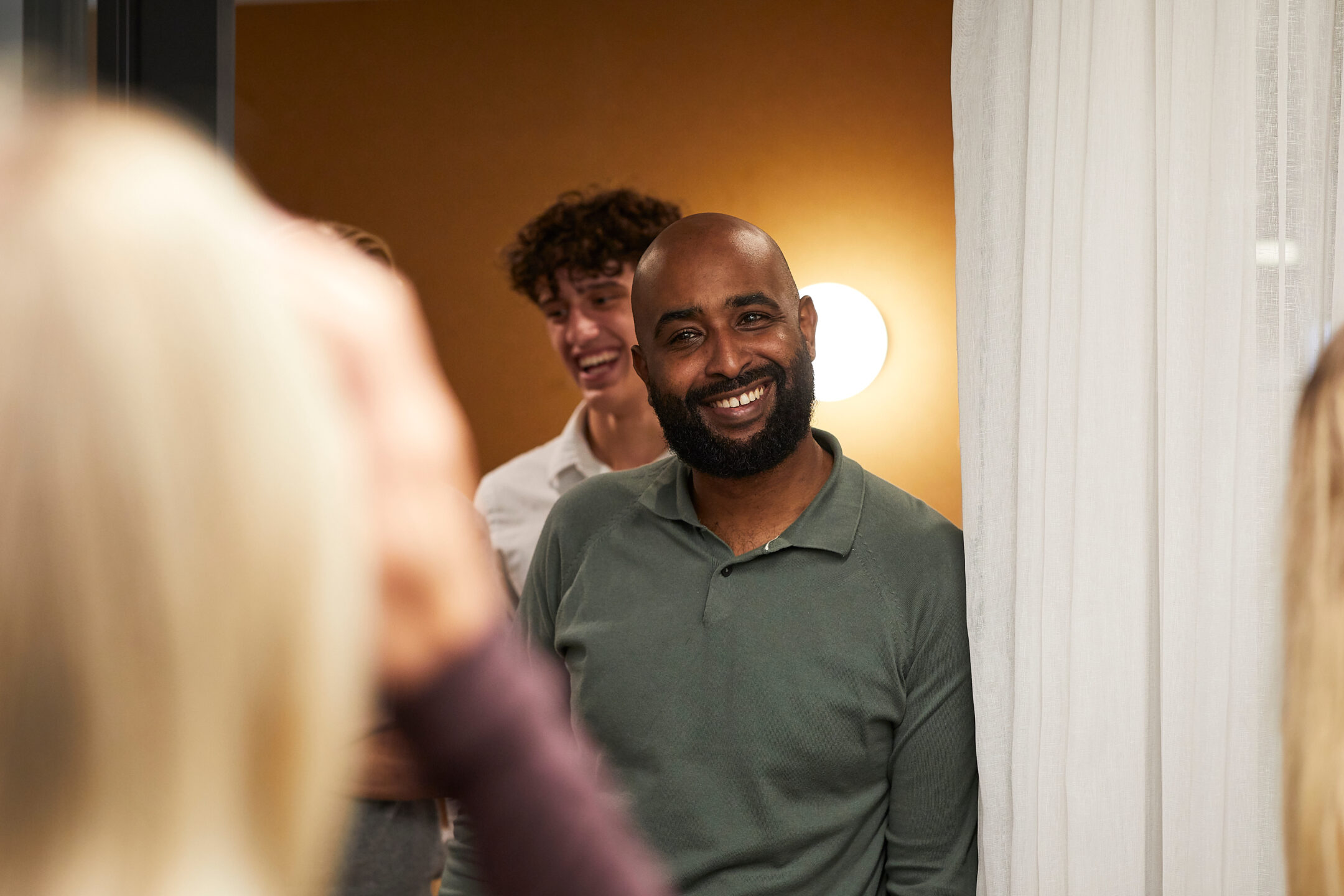 A colleague smiling during a conversation with the team